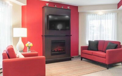 Lobby lounge with TV screen and fireplace at Comfort Inn Fredericton.