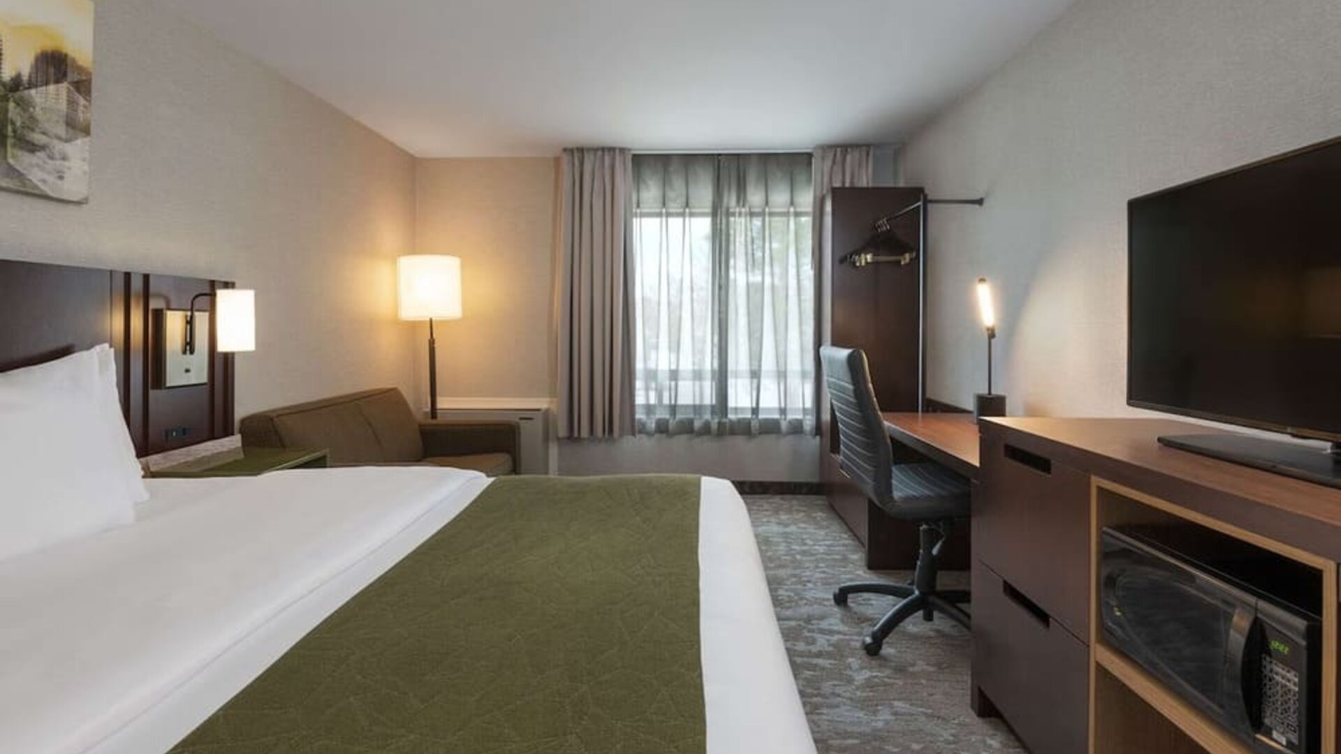 Bright and spacious day use room with TV, work desk and sofa at Comfort Inn Fredericton.