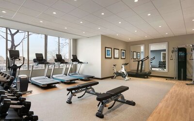 Fully equipped fitness center with window view at the Embassy Suites by Hilton Toronto Airport.