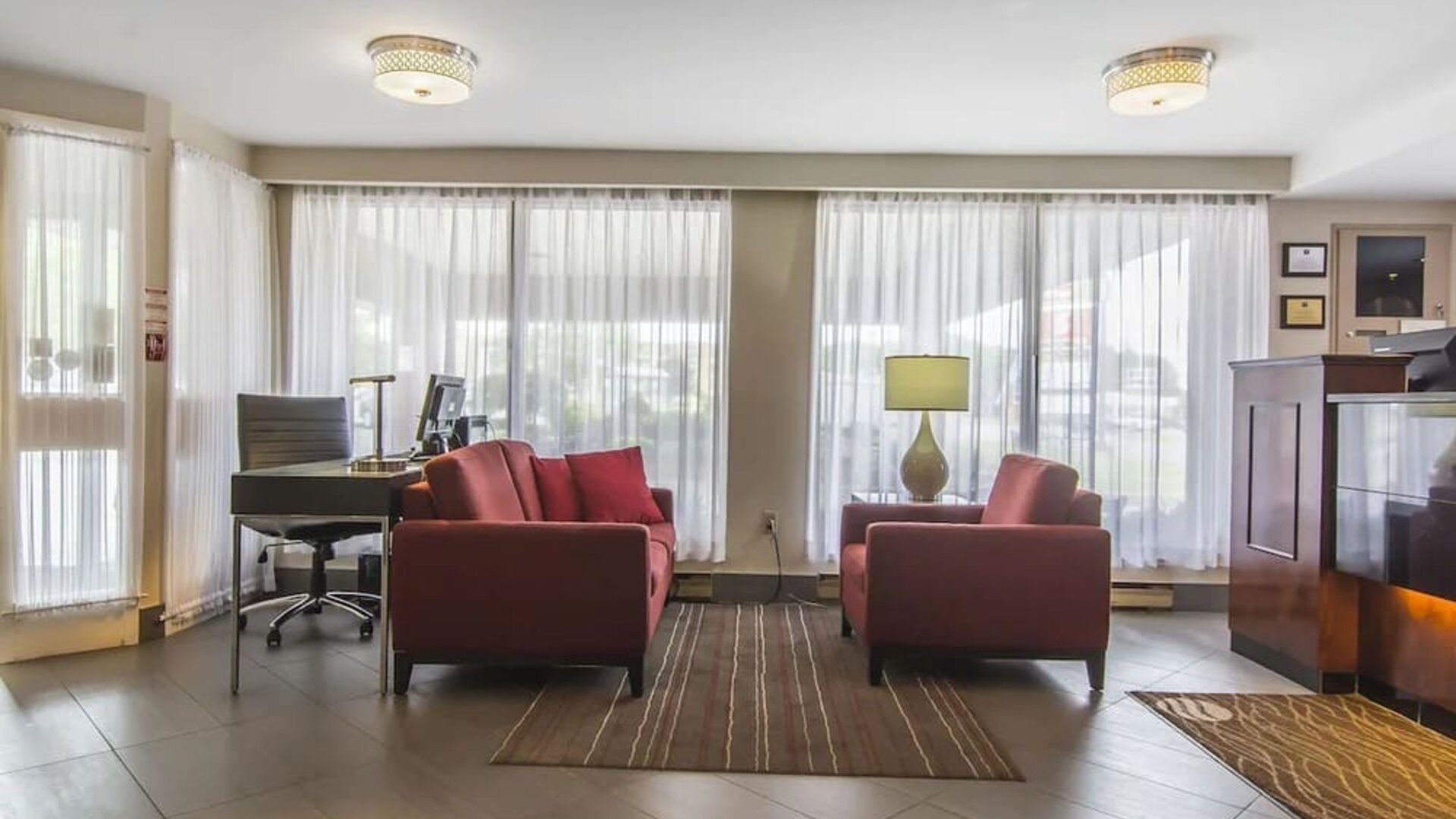 The hotel lobby has comfortable seating, and is brightly lit thanks to large windows.