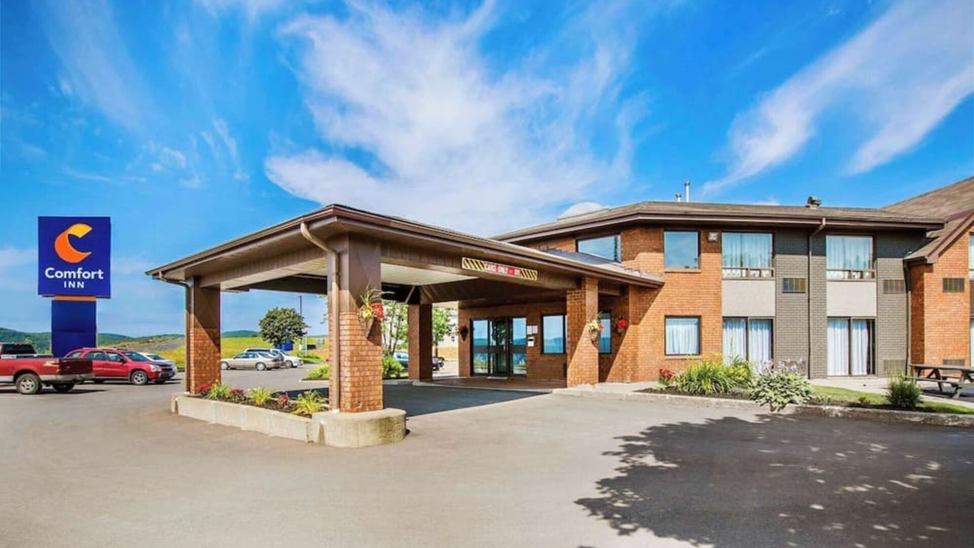 Hotel exterior and parking area at Comfort Inn Sydney.