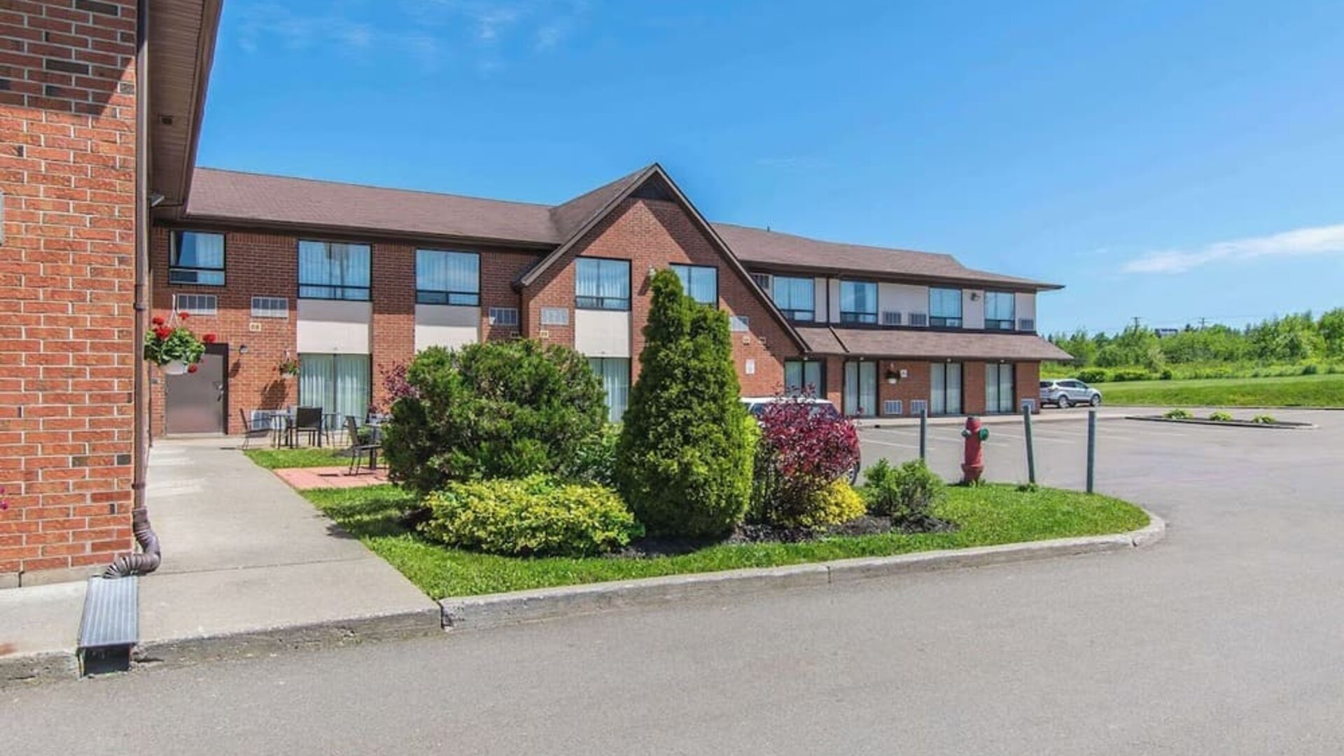 Hotel exterior with lounge seating and parking area at Comfort Inn Moncton Magnetic Hill.