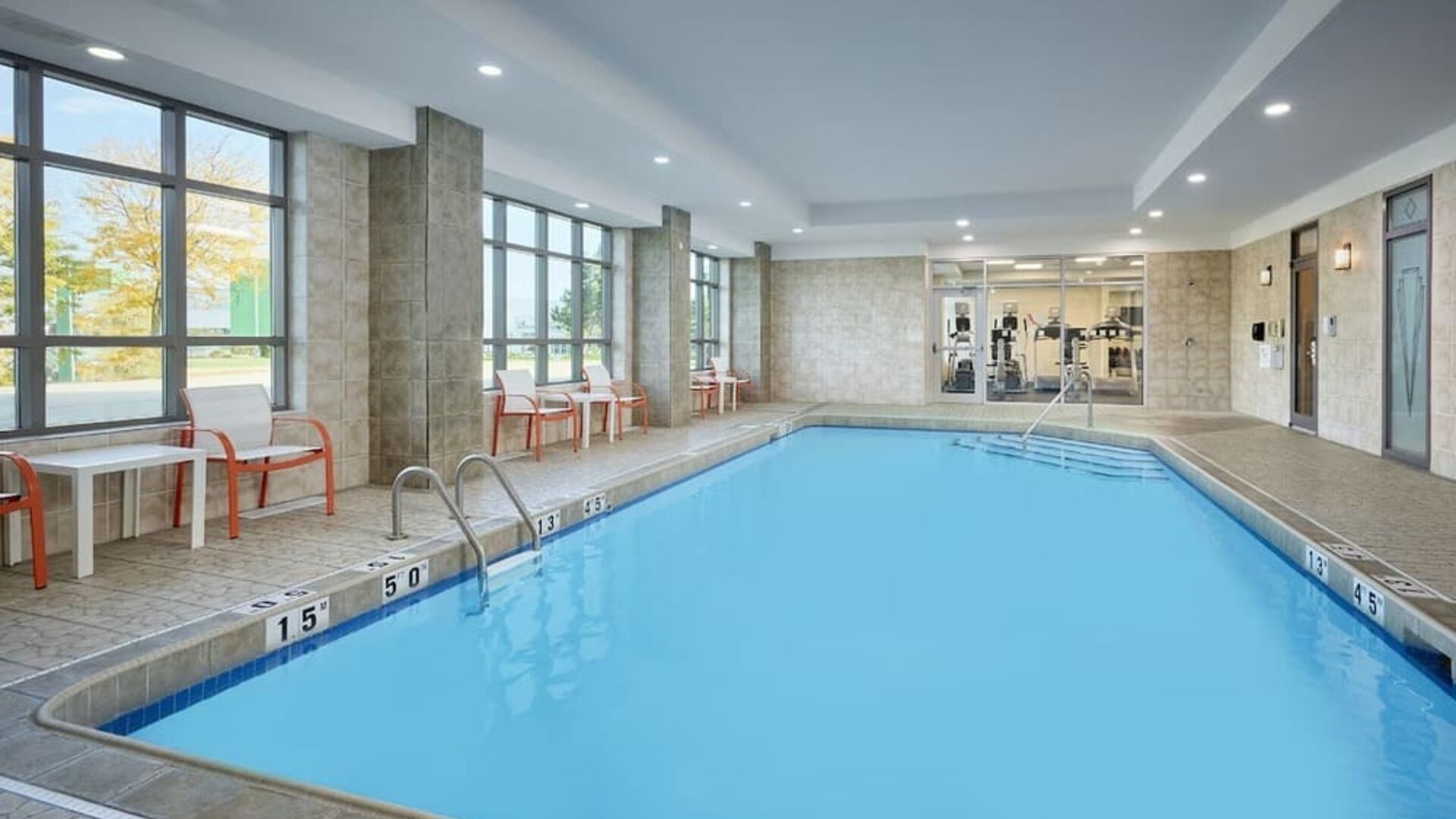 Indoor heated pool with lounge chairs at Holiday Inn & Suites Oakville At Bronte.