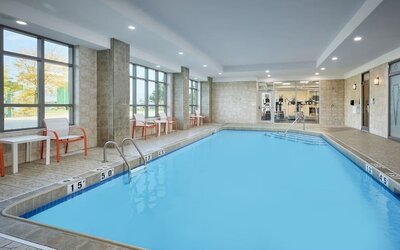 Indoor heated pool with lounge chairs at Holiday Inn & Suites Oakville At Bronte.
