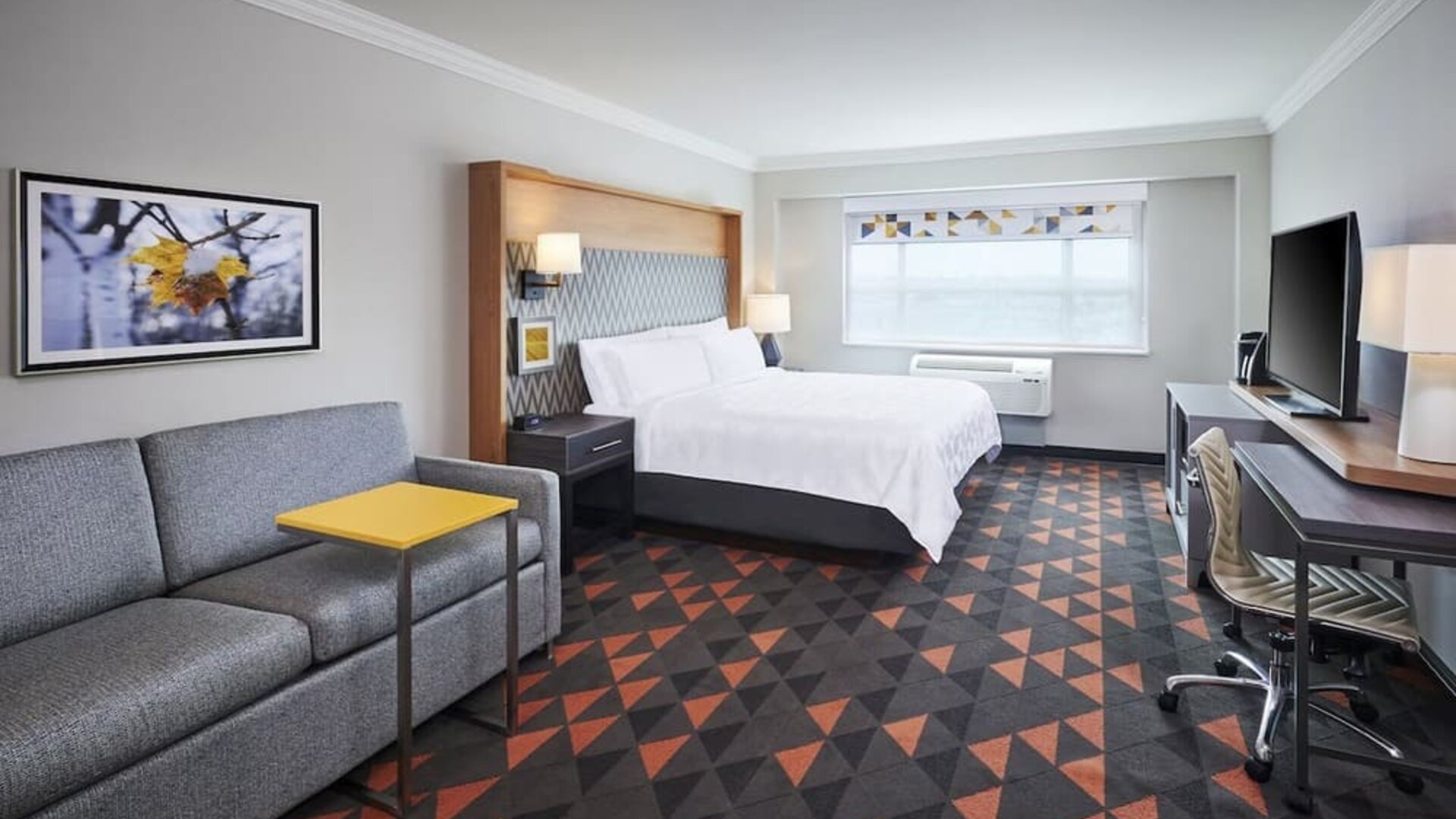 Day use room with TV, work desk and living area at Holiday Inn & Suites Oakville At Bronte.