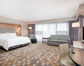 Bright and spacious king room with work desk and sofa at Holiday Inn Toronto Airport East.