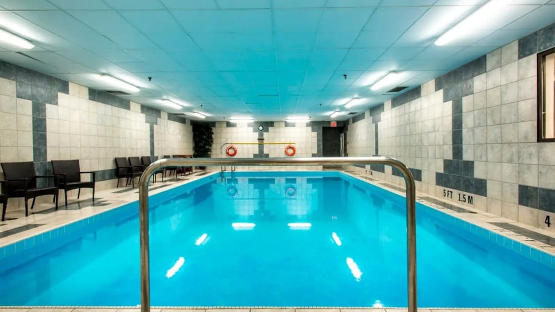 Indoor heated pool with lounge chairs at Halifax Airport Hotel.