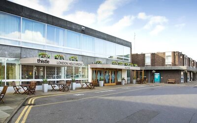 Hotel entrance with outdoor sitting area at Thistle London Heathrow Terminal 5.