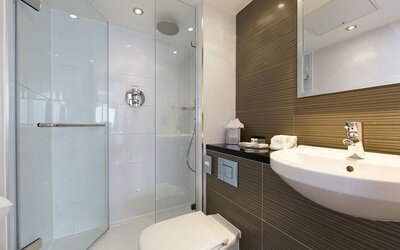 Guest bathroom with shower and free toiletries at Thistle Royal Trafalgar Square.
