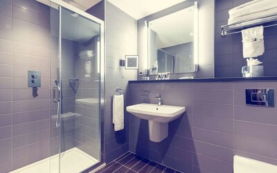 Guest bathroom with shower at Mercure Hotel London Paddington.