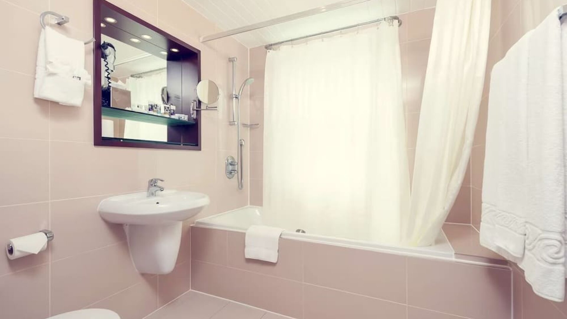 Guest bathroom with tub at Mercure Hotel London Paddington.