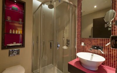 Guest bathroom with shower and free toiletries at Hotel Indigo London Paddington,