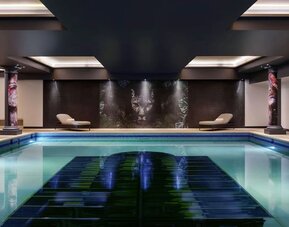 Relaxing indoor pool with lounge chairs at NYX Hotel London Holborn By Leonardo.