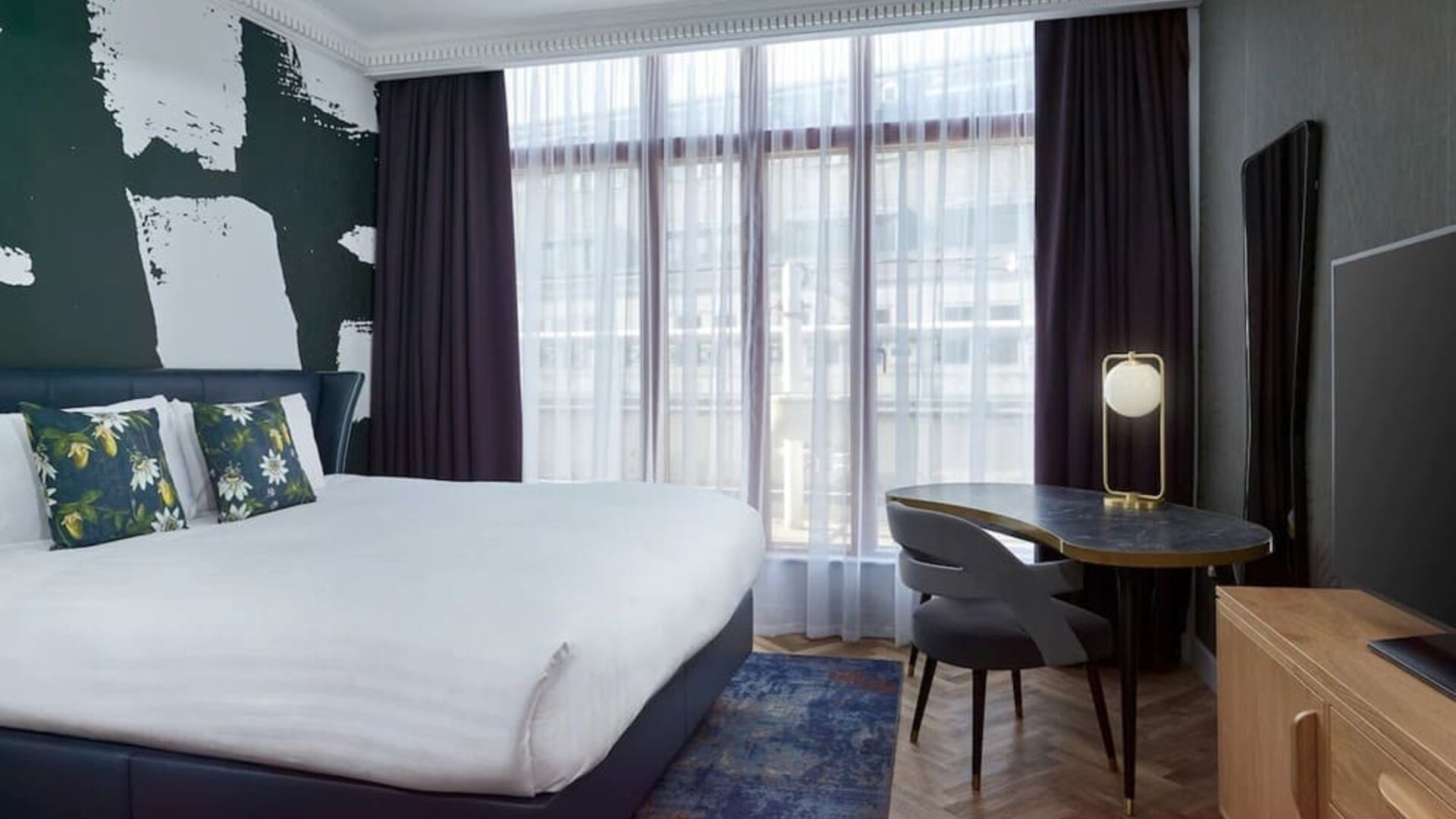 Bright and spacious day use room with king bed, TV screen and work desk at NYX Hotel London Holborn By Leonardo.