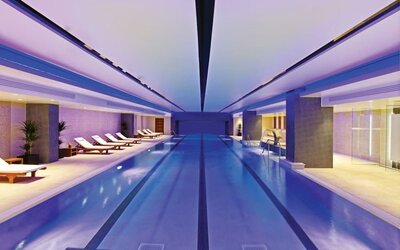 Relaxing indoor pool with lounge chairs at Leonardo Royal Hotel London Tower Bridge.