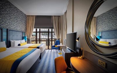 Day use twin room with TV screen, work desk and lounge seating at Leonardo Royal Hotel London City.