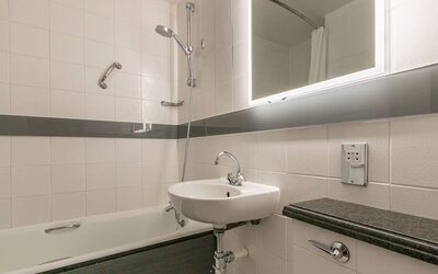 Guest bathroom with combined tub and shower at Thistle Express London, Luton.