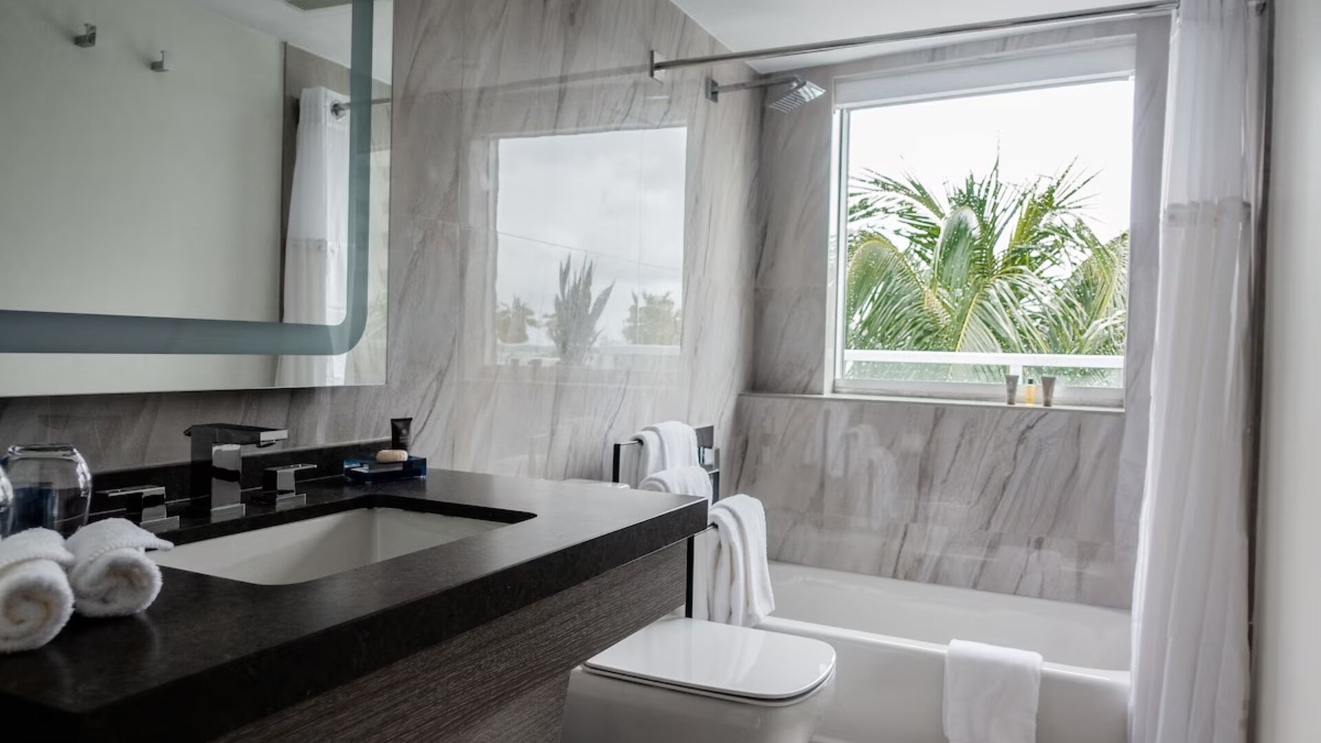 Guest bathroom with shower and tub at The Sagamore Hotel South Beach.
