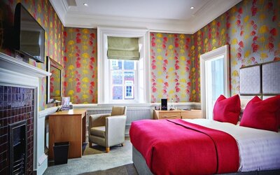 Day use room with work desk, TV screen and fireplace at Barnett Hill Hotel.