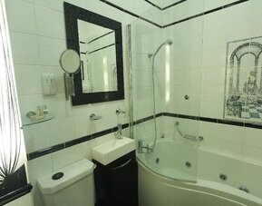 Private bathroom with tub and free toiletries at Opulence Central London Hotel.