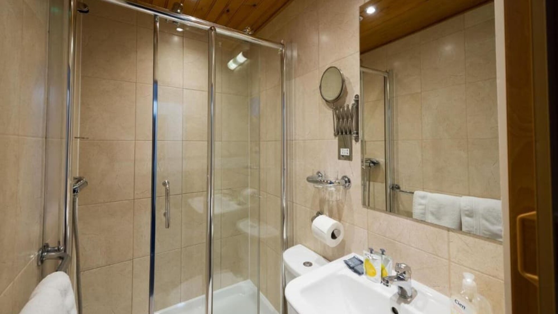Private guest bathroom with shower and free toiletries at Adria Hotel.