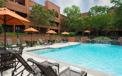 Refreshing outdoor pool with plenty of sun loungers at DoubleTree Suites By Hilton Hotel Charlotte - SouthPark.
