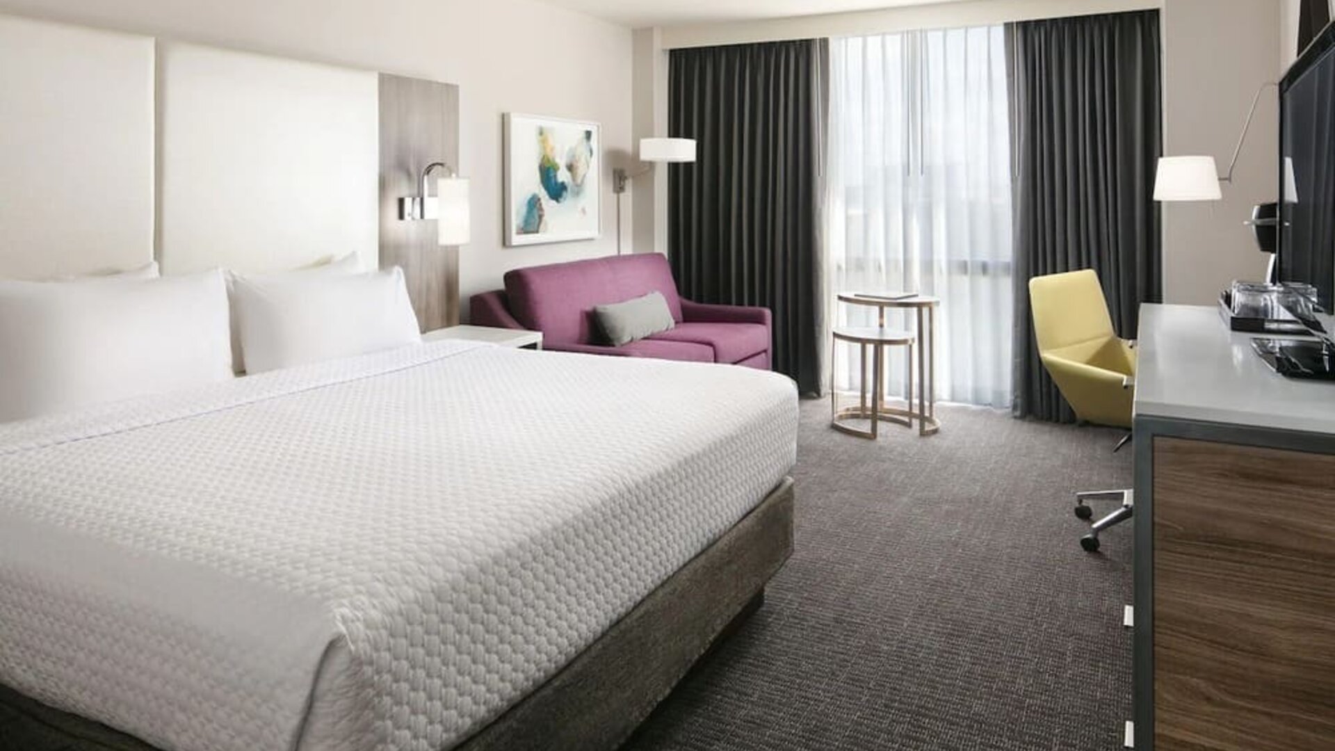 Day use room with work desk and sofa at Crowne Plaza Dallas Market Center.
