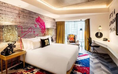 Bright and spacious day use room with floor to ceiling window and work desk at nhow London.