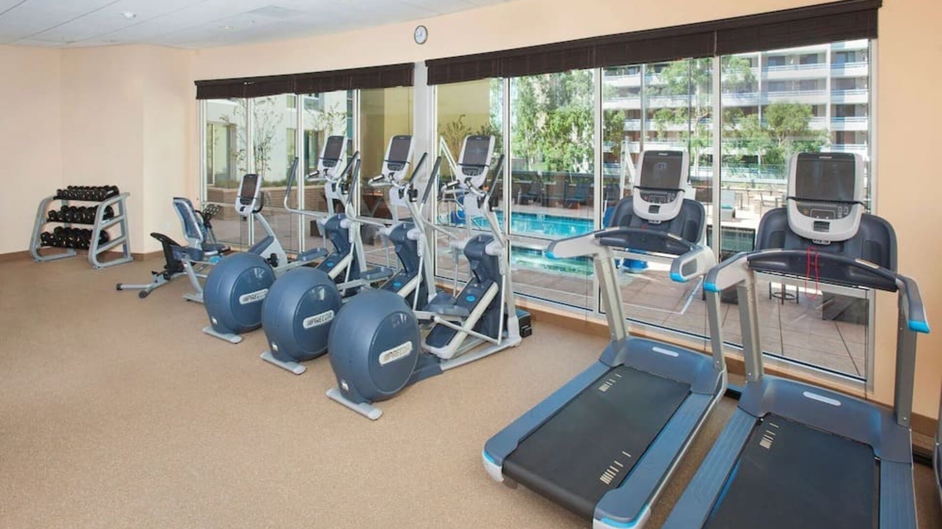 Fitness facility with a view of the pool at Hilton Garden Inn Burbank Downtown.