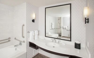 Guest bathroom with shower and tub at Hilton Garden Inn Burbank Downtown.