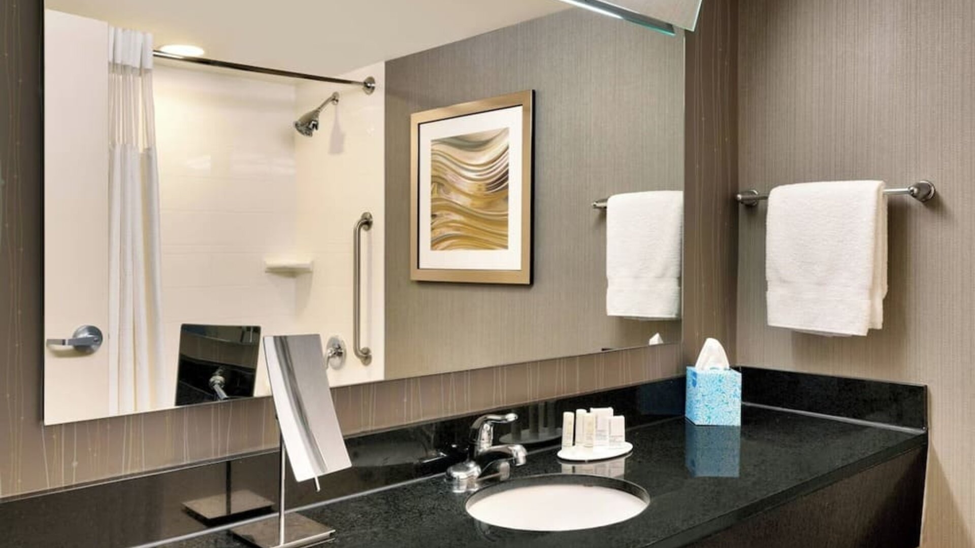 Guest bathroom with shower at Courtyard By Marriott Charlotte Airport/Billy Graham Parkway.