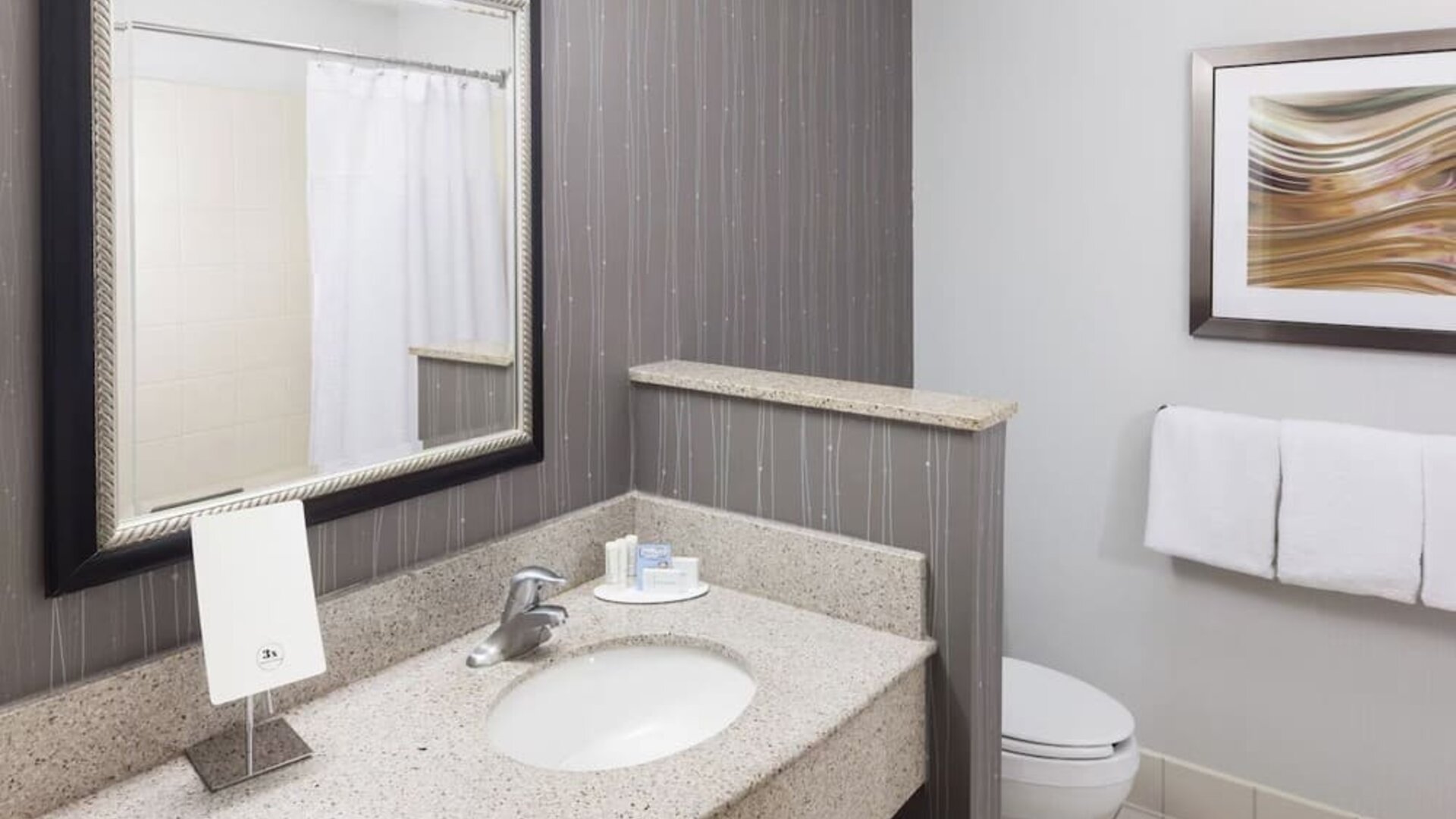 Guest bathroom with shower at Courtyard By Marriott Hattiesburg.