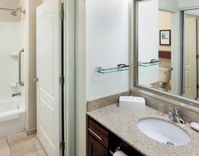 Guest bathroom with shower and tub at Residence Inn By Marriott Hattiesburg.