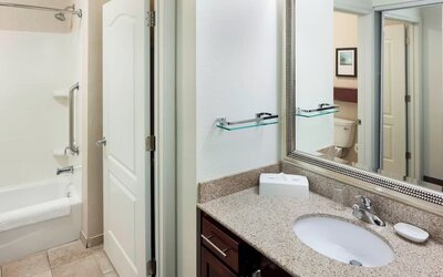 Guest bathroom with shower and tub at Residence Inn By Marriott Hattiesburg.