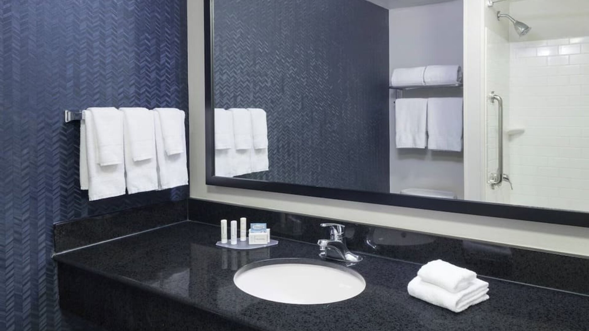 Guest bathroom with shower and tub at Fairfield Inn & Suites Kansas City Overland Park.