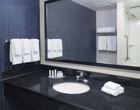Guest bathroom with shower and tub at Fairfield Inn & Suites Kansas City Overland Park.