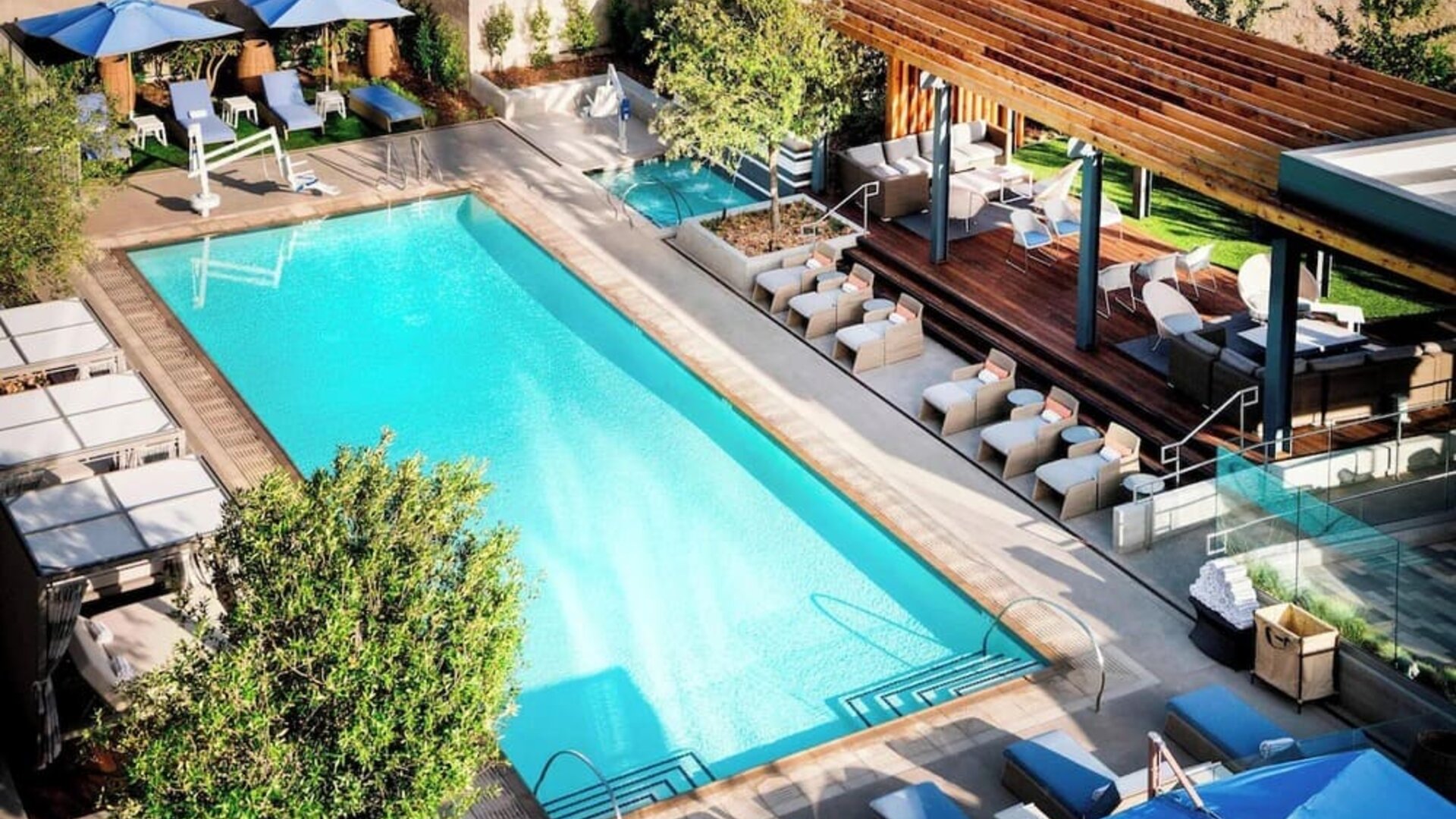 Refreshing outdoor pool surrounded by pool chairs at Hotel Nia, Autograph Collection.