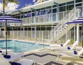 Refreshing outdoor pool and sun loungers at Plunge Beach Resort.