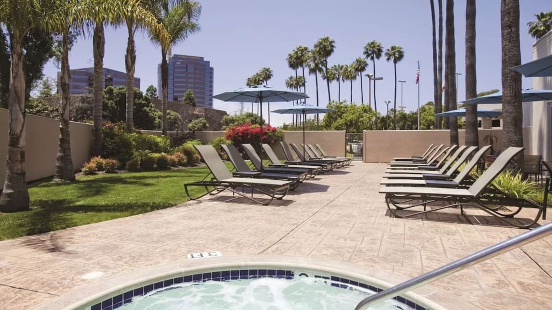 Outdoor pool with lounge chairs at Embassy Suites By Hilton San Diego-La Jolla.