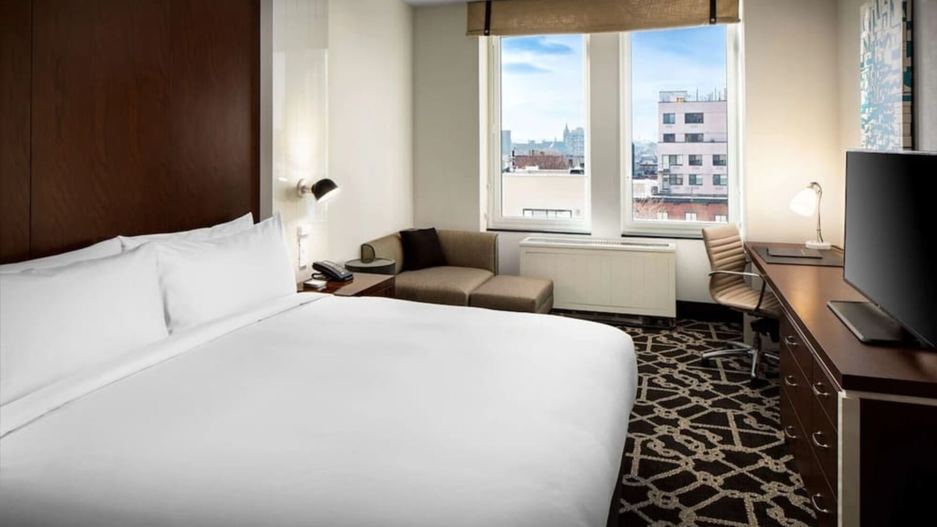 King-sized bed with work desk at Hilton Brooklyn New York.