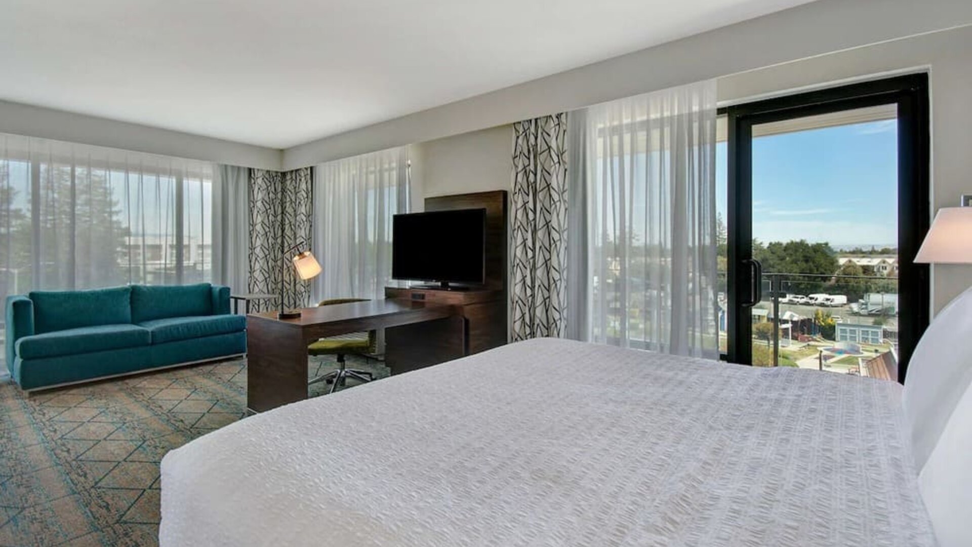 Day use room with work desk, sofa and balcony at Hampton Inn & Suites Sunnyvale Silicon Valley.