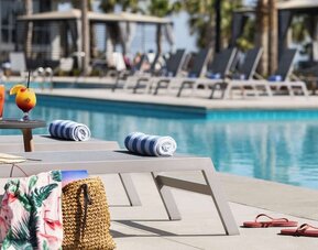 Sun loungers surrounding the pool at Embassy Suites By Hilton Myrtle Beach Oceanfront Resort.