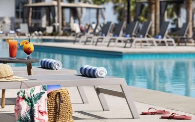 Sun loungers surrounding the pool at Embassy Suites By Hilton Myrtle Beach Oceanfront Resort.