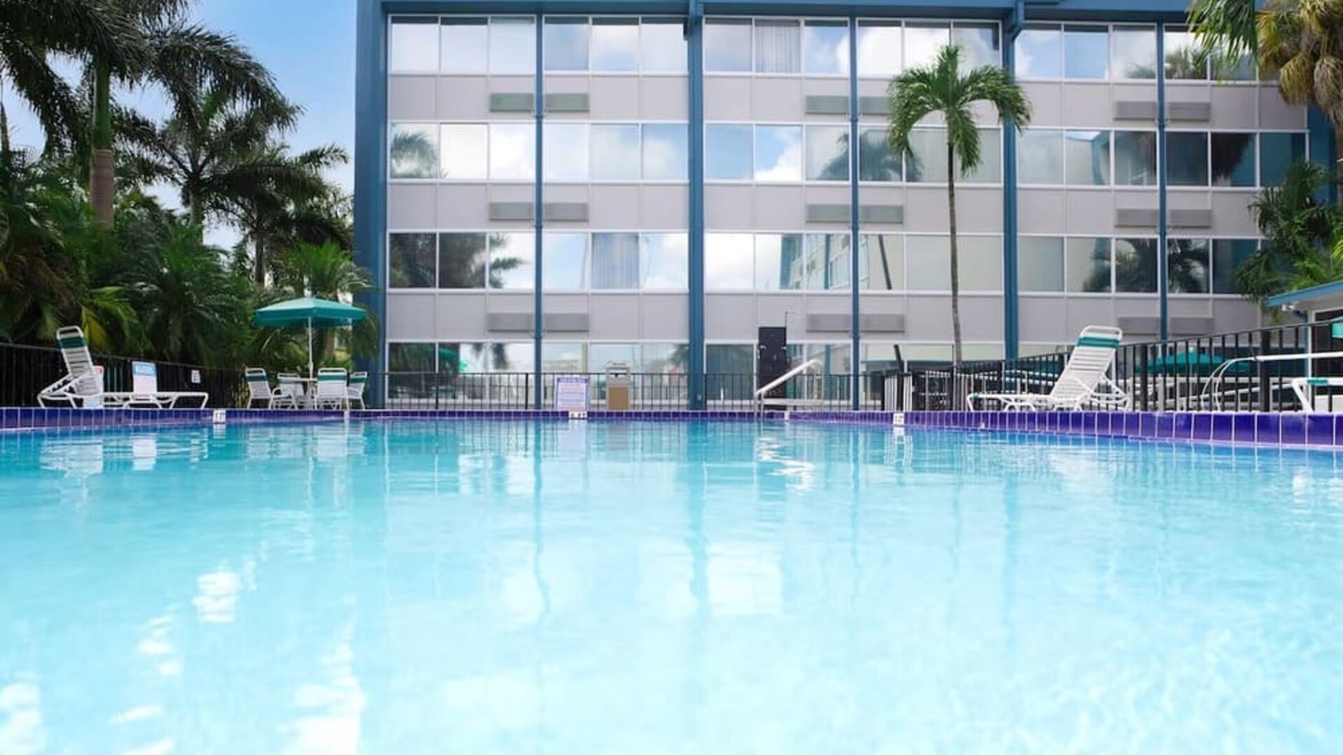 Relaxing outdoor pool with lounge area at EnVision Hotel Miami International Airport.