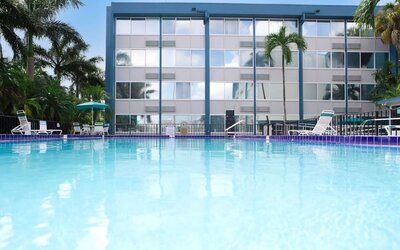Relaxing outdoor pool with lounge area at EnVision Hotel Miami International Airport.