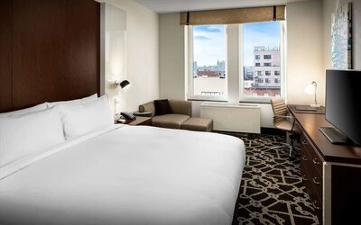 Day use room with work desk and lounge seating at Hilton Brooklyn New York.