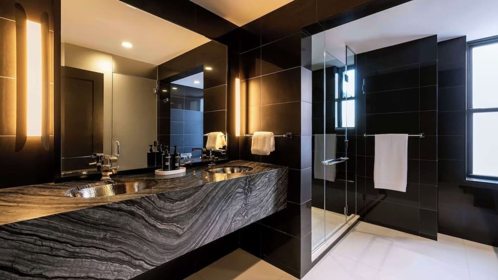 Private guest bathroom with shower and free toiletries at The Benjamin Royal Sonesta New York.