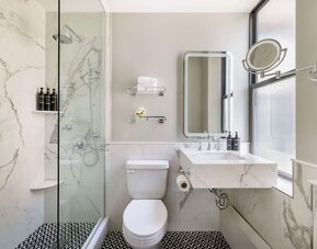 Private guest bathroom with shower at The Benjamin Royal Sonesta New York.