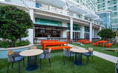 Alfresco dining and lounge area beside a bar at Hilton Orlando.