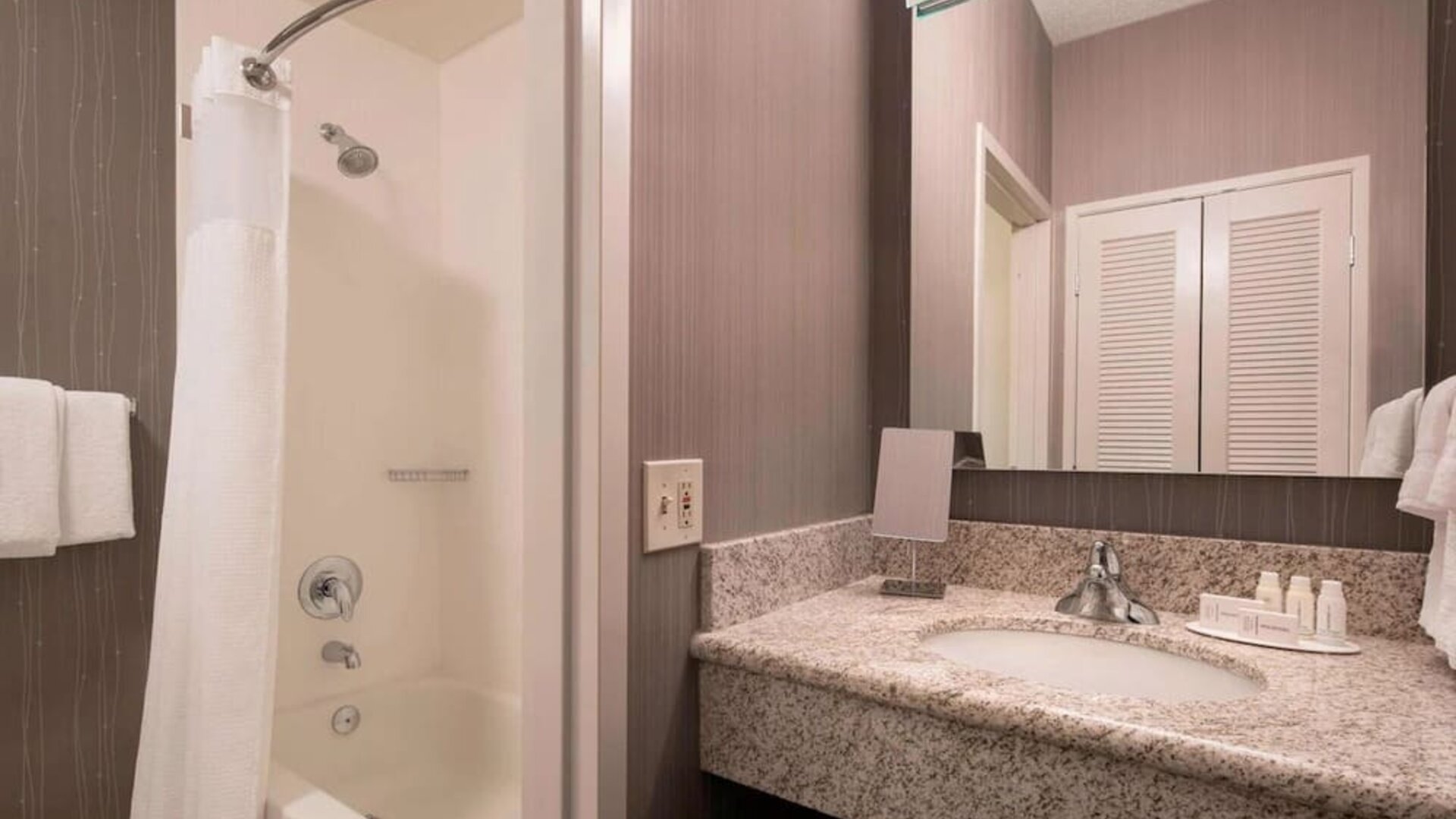 Private guest bathroom with shower and free toiletries at Sonesta Select Tempe Downtown.